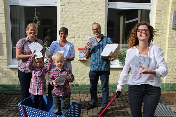 Kinderdorfmutter mit Kindern, buntem Bollerwagen und anderen Beteiligten