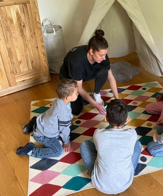 Gruppenleiterin Anna-Lena Morsch spielt mit den Kindern im Kinderzimmer vor dem Tipi-Zelt