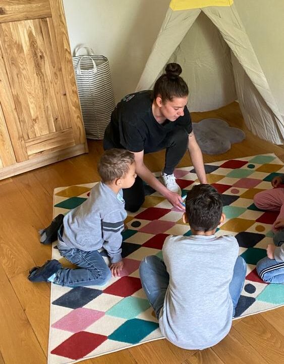 Gruppenleiterin Anna-Lena Morsch spielt mit den Kindern im Kinderzimmer vor dem Tipi-Zelt