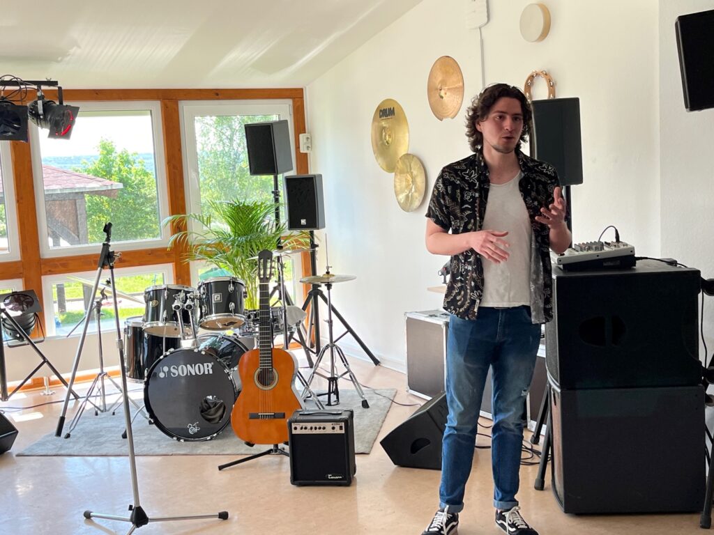 Musikstudent Camilo zeigt den neuen Musikraum, in dem er den Kindern künftig Musikunterricht geben wird